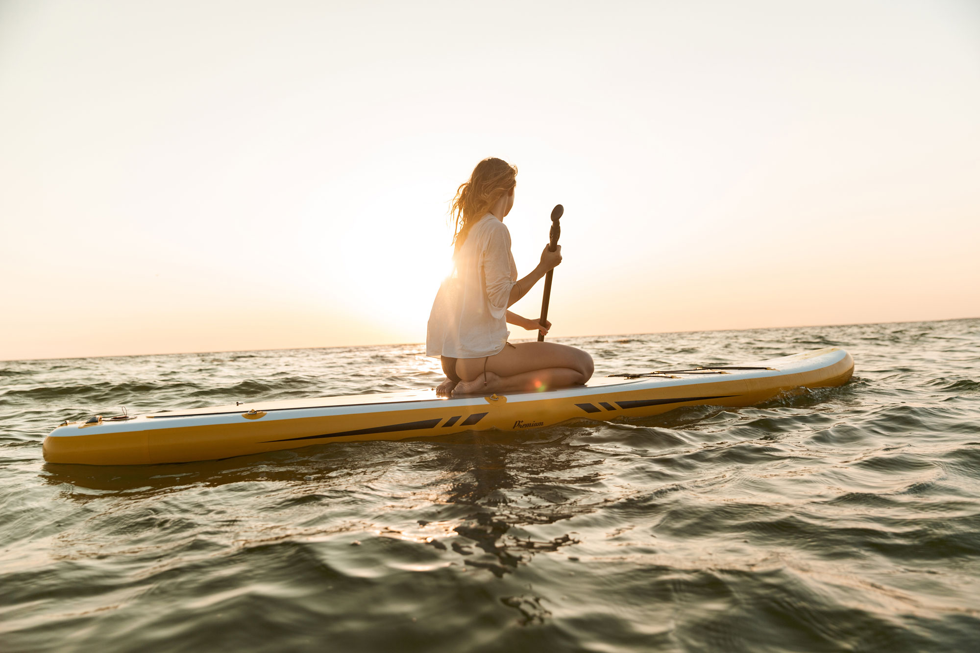 Young female paddle boarding